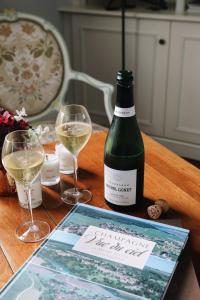 埃佩尔奈La Villa by Michel Gonet的桌子上放有一瓶葡萄酒和两杯酒