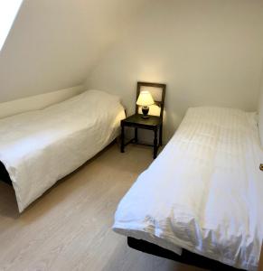 马里博Torvet 19 - Maribo的配有两张床铺的客房设有一张带台灯的边桌