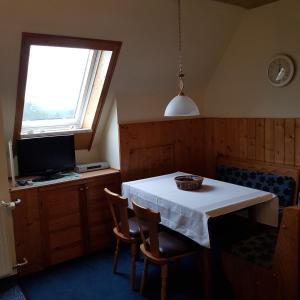 库罗阿尔滕堡Ferienwohnung Heinrich的一间设有白色桌子和窗户的用餐室