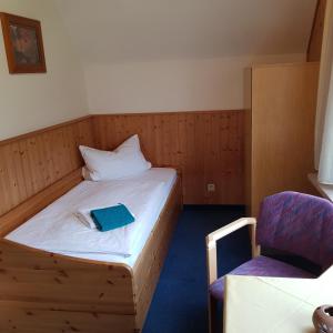 库罗阿尔滕堡Ferienwohnung Heinrich的一间小卧室,配有一张床和一把椅子
