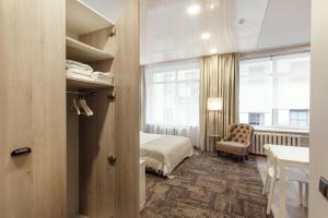 维尔纽斯Old Town Trio Apartments的卧室配有床、椅子和窗户。