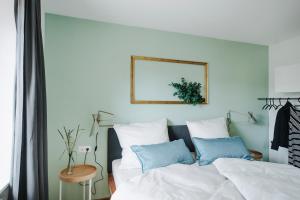 布雷根茨Rotes Haus Bregenz Wald Wohnung的一间卧室配有带白色床单和蓝色枕头的床。