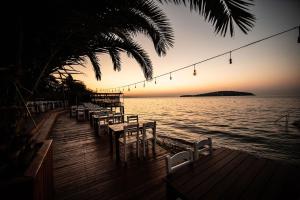 王子岛群Büyükada Loc'ada的日落时分水面上配有桌椅的码头