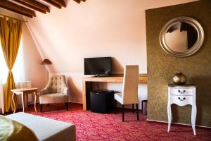 锡纳亚斜森林spa旅馆的酒店客房配有一张桌子、一张床和镜子