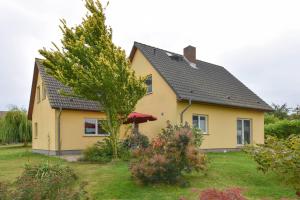 PudaglaFerienhaus Inselnest的黑色屋顶的黄色房子