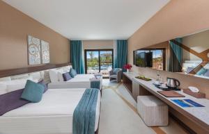 沃科利达Nuh'un Gemisi Deluxe Hotel & Spa的酒店客房配有两张床和一张书桌