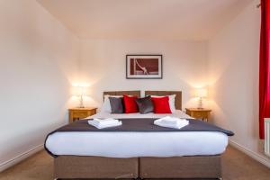 卡迪夫Watkins House by Cliftonvalley Apartments的一间卧室配有一张带红色枕头的大床