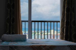 麦克坦Gibzon's Invitation Suites near Mactan airport的一间卧室配有一张床,享有海景