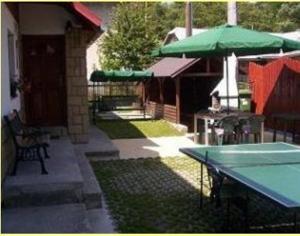 奥什恰德尼察查鲁帕余得拉巴旅馆的一个带桌子和遮阳伞的庭院