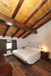 布勒伊-切尔维尼亚霍斯奎特酒店的一间卧室设有一张带木制天花板的大床。