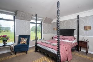 吉尔福德吉尔福德庄园酒店及Spa的一间卧室配有四柱床和椅子