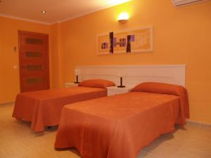 托梅略索牵牛花住宿旅游公寓的橙色墙壁客房的两张床
