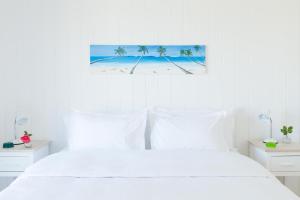 埃斯特角城Casa Flor的白色卧室,配有白色的床和棕榈树