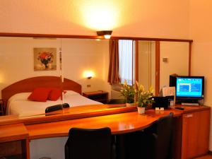 拉伊纳泰高尔夫酒店的一间卧室配有一张床和一张带电脑的书桌