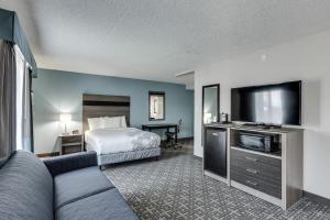 斯波坎Days Inn & Suites by Wyndham Spokane的配有一张床和一台平面电视的酒店客房