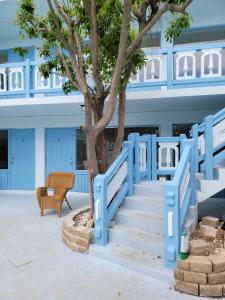 劳德代尔堡Hotel Motel Lauderdale Inn的一座有树的建筑前方的蓝色楼梯