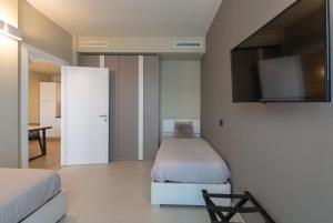 博尔加罗托里内塞ATMOSFERA APARTMENTS & SUITES的一间卧室配有一张床和一台平面电视