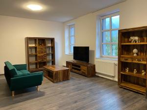 利贝雷茨Boutique Apartments Liberec的客厅配有电视、沙发和椅子