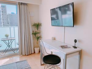 东京intheHood Tsukiji - Vacation STAY 97734的一间房间,配有一张桌子和一台墙上的电视