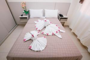 锡诺普Flats Andira Kuss的一张铺有白色床单和鲜花的床