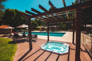 伊瓜苏Cataratas Park Hotel e Eventos的木甲板,设有游泳池和木制凉亭