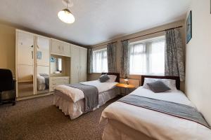 阿克斯桥OYO Honeycroft Lodge的酒店客房设有两张床和电视。