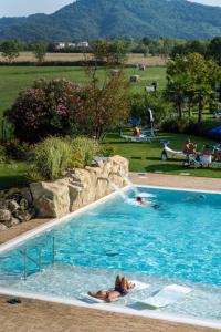 阿巴诺泰尔梅Hotel Terme Leonardo的在带喷泉的游泳池游泳的人
