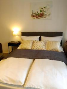 巴登-巴登Rivulet 2 bedroom Apartment的一张带白色床单和枕头的床