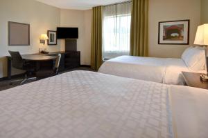圣克莱尔斯维尔Candlewood Suites St Clairsville Wheeling Area, an IHG Hotel的酒店客房配有两张床和一张书桌