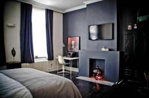 布鲁塞尔九十家住宿加早餐旅馆的一间卧室配有一张床、一张桌子和一个壁炉