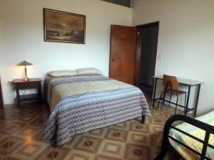塔巴贝拉Quito Eco Lodge Airport - B&B的一间卧室配有一张床、一张桌子和一张书桌