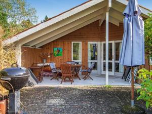 埃贝尔托夫特Holiday Home Lærkevej VI的房屋设有带桌子和遮阳伞的庭院