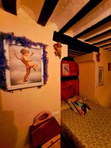 昆卡La Ronda的一间设有一张床的客房,墙上挂着一幅画