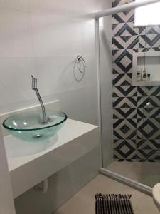 阿拉亚尔-杜卡布Apartamento Elizabetta 3, pé na areia的一间带玻璃水槽和淋浴的浴室