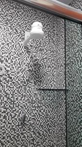 马瑙斯Edward Suíte Manaus 03的瓷砖墙上的灯光淋浴