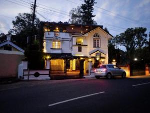 乔奥诺奥尔Kumar's Mountain View Cottage的停在白色房子前面的汽车