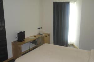 维多利亚-加斯特伊兹戈贝欧公园酒店的一间卧室配有一张床和一张书桌及电视