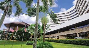 怡保怡保宴宾雅酒店的一座棕榈树环绕的大建筑
