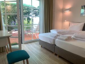 明斯特Park-Lodge Am Rohrbusch的酒店客房设有两张床和一个阳台。