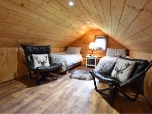 Dallavich奥赛湖景山林小屋的一间卧室配有一张床和一个沙发