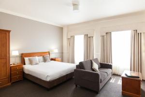 阿德莱德莫杰斯蒂克泰特街公寓酒店的配有一张床和一把椅子的酒店客房