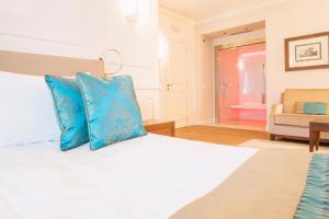 西尔米奥奈泰尔梅大酒店的一间卧室配有一张带蓝色枕头的床