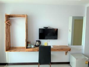 南府Nan Panwa Hotel的客房设有书桌和墙上的电视