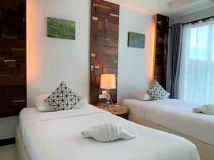南府Nan Panwa Hotel的白色墙壁客房的两张床