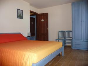 圣克兹索佐帕特里齐亚别墅酒店的卧室配有一张床和一张桌子及椅子