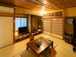京都藤家旅馆的客厅配有桌子和电视