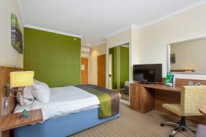 利明顿温泉Holiday Inn Leamington Spa - Warwick, an IHG Hotel的一间卧室配有一张床、一张书桌和一台电视
