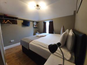 伦敦Belgravia Rooms Hotel的一间卧室配有一张床和一张带台灯的书桌
