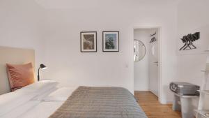 波恩Beethoven Hotel Dreesen - furnished by BoConcept的白色卧室配有一张床,墙上挂有图片