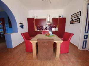 MonyoródVakantiehuis Casa Mama met prive zwembad的厨房配有木桌和红色椅子